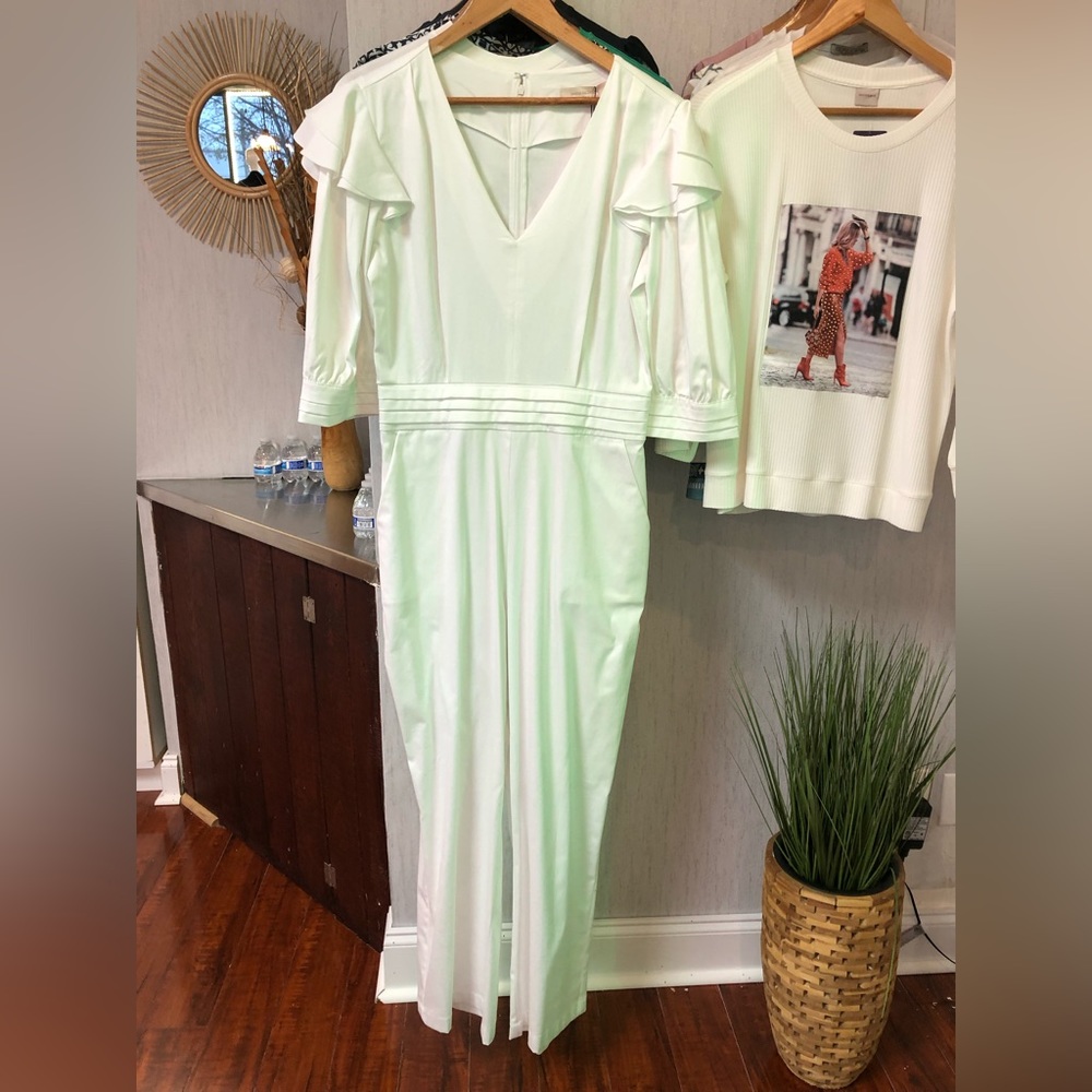 White jumpsuit with button detail on sleeve.